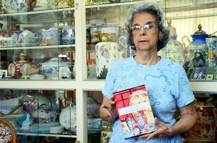 Professora Therezinha exibe seu primeiro livro sobre pintura em porcelana e faiança. (Foto: Luis Claudio Antunes/PortalR3)