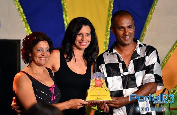 Guilherme e Valquíria recebem o troféu de campeão da secretária de Educação, Cidinha Pedroso. (Foto: Luis Claudio Antunes/PortalR3)