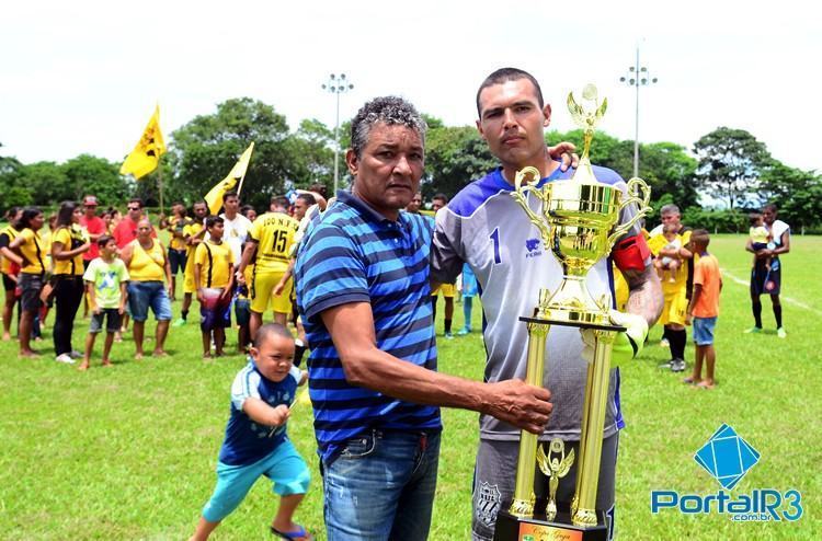 "Baiano", pai de Luiz Gustavo, entregou o troféu de campeão ao goleiro Tiago Pedro, capitão do 100 Nome FC. (Foto: Luis Claudio Antunes/PortalR3)