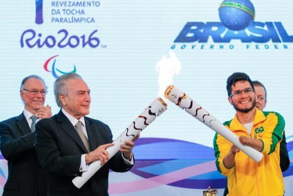 O presidente interino Michel Temer e o velocista Yohansson Nascimento acendem a tocha paralímpica no Palácio do Planalto. (Foto: Beto Barata/Presidência da República)