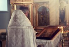 Padre rezando em uma igreja.
