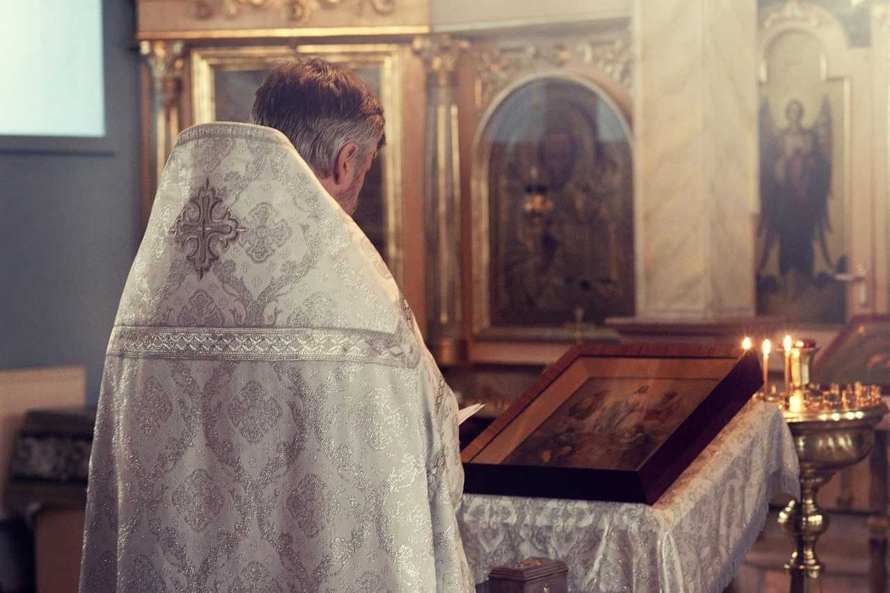 Padre rezando em uma igreja.