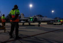 A equipe de solo da Força Aérea Sueca aguarda enquanto os caças JAS 39 Gripen se preparam para taxiar para decolar na Base Aérea de Leeuwarden, na Holanda, durante o exercício Ramstein Flag 25.
